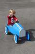 Foto: Junge winkend in seinem blauen Tretauto Junge winkend in seinem blauen Tretauto
