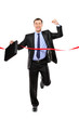 Full length portrait of a businessman running at the finish line