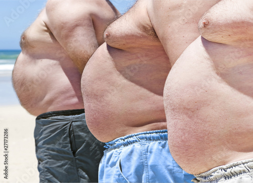 Photo: Close up of three obesely fat men on the beach Close up of three obesely fat men on the beach