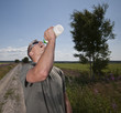 Foto: Male athlete drinking water on hot summer day. Male athlete drinking water on hot summer day.