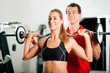 Personal Trainer und Frau im Fitnessstudio