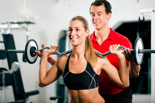 Photo: Woman with Personal Trainer in gym Woman with Personal Trainer in gym