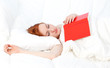 young woman with red book in white bedding young woman with red book in white bedding