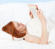 young woman with red book in white bedding young woman with red book in white bedding