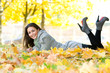 Happy student girl lying in autumn leaves with netbook Happy student girl lying in autumn leaves with netbook
