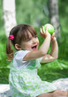 Little girl portrait with green apple in her hands outdoor