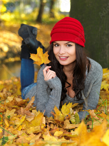 Foto: Beautiful woman spending time in park during autumn season Beautiful woman spending time in park during autumn season