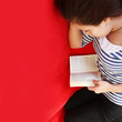 Mädchen liesst ein Buch auf dem Sofa