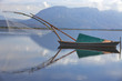 fisherman boat reflection and mountain on the horizon