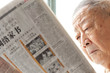 a senior man is reading newspaper