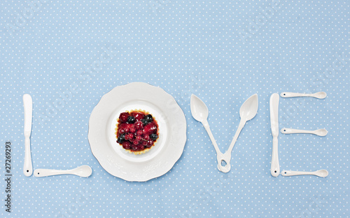 Photo: silverware and plate with tart spelling "love" on tablecloth silverware and plate with tart spelling "love" on tablecloth
