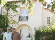 smiling senior couple outside house