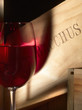 Glass of red wine and a wooden box Bacchus