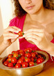 Woman taking the peduncles off the tomatoes