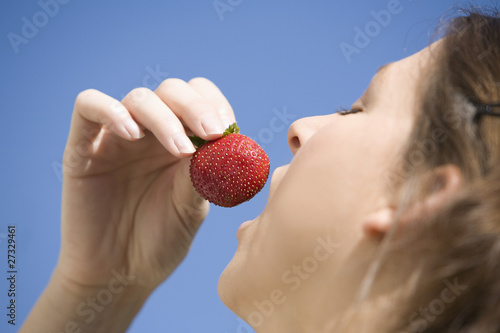 Photo: Woman eating a strawberry Woman eating a strawberry