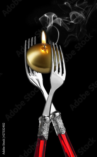 Photo: Two forks with golden candle ;candle light diner Two forks with golden candle ;candle light diner