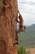 Photo: Rock climber on the cliff with mountainous background Rock climber on the cliff with mountainous background