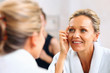 Beautiful mature woman admiring herself in the mirror Beautiful mature woman admiring herself in the mirror