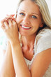 Relaxed blue eyed woman smiling , hands clasped Relaxed blue eyed woman smiling , hands clasped