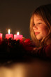 Mädchen schaut auf Adventskranz