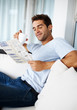 Young man reading newspaper with a cup of coffee