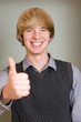 Happy casual young man showing thumb up and smiling