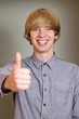Happy elegant young man showing thumb up