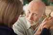 Senior couple at home holding hands focusing on man