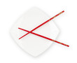 White plate with red chopsticks isolated with clipping path incl