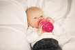 Foto: Baby Girl auf Kissen trinkt aus ihrem Fläschchen Baby Girl auf Kissen trinkt aus ihrem Fläschchen