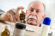 Senior man picking medicine bottle Senior man picking medicine bottle