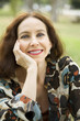 Foto: Portrait of a middle age woman smiling in the park Portrait of a middle age woman smiling in the park
