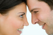 Young couple with heads together, smiling, side view, close-up