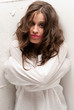 Young insane woman with straitjacket looking at camera close-up