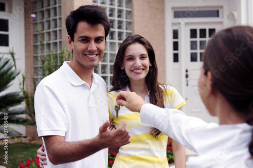 Photo: Real estate agent handing over house key Real estate agent handing over house key