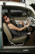 a girl sitting inside an antique car with sun glasses