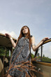 girl posing with antique car with blue sky as background