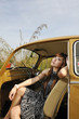 girl sit inside vintage car holding sun glasses