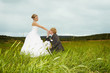 Groom kisses hand of bride in field