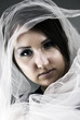 a young girl wrapped in the white sheer scarf