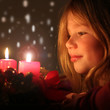 Mädchen betrachtet Adventskranz
