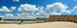 Versailles Palace facade and golden fence over blue sky