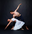 Graceful dancers performing against black background