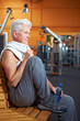 Seniorin im Fitnessstudio ruht sich aus