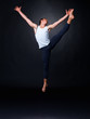 Male ballet dancer dancing energetically against black Male ballet dancer dancing energetically against black