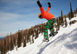 Snowboarder jumping through air with  blue sky in background