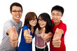 Four young teenagers laughing and giving the thumbs-up