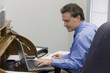 Photo: Businessman working on his laptop and using records Businessman working on his laptop and using records