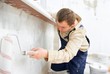 worker painting wall with roller.