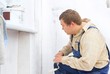 builder looking at the paint wall with roller in hands. builder looking at the paint wall with roller in hands.